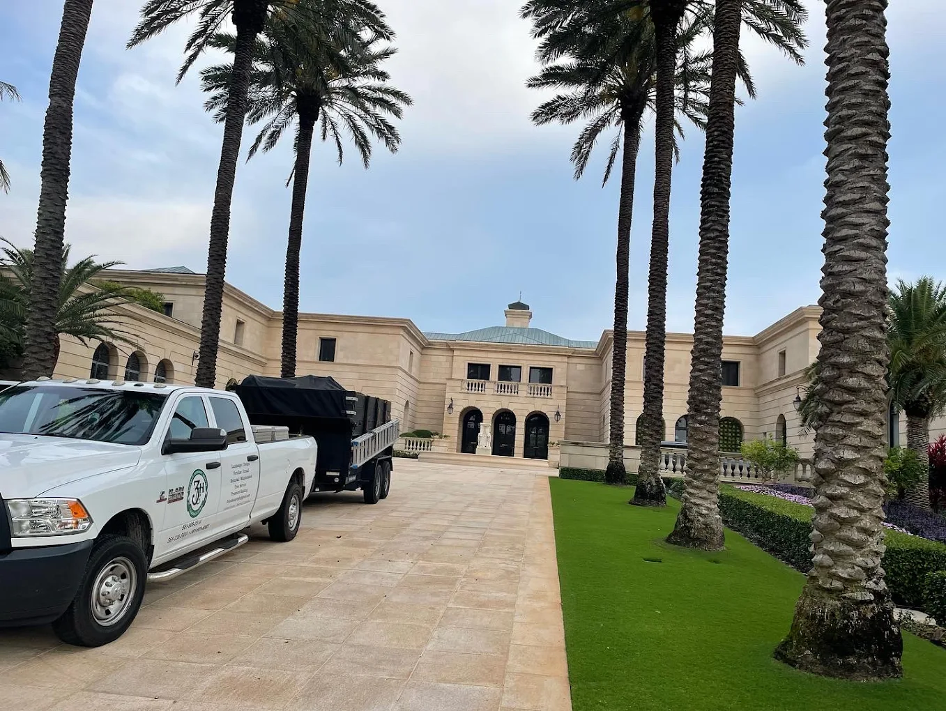 Luxury estate landscaping with manicured lawn and palm trees